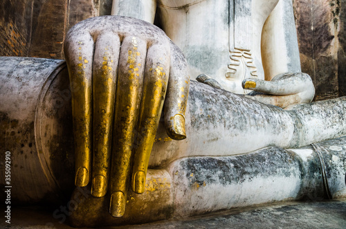 Detail of the golden hand of Phra Achana, an old large historic Buddha statue at Wat Si Chum in Sukhothai, Thailand