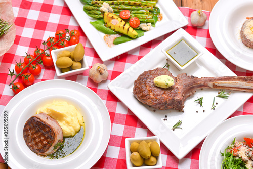Dinner Table Concept. Italian cuisine, Italian concept. Flat lay banner. Tomahawk steak, avocado and asparagus salad.