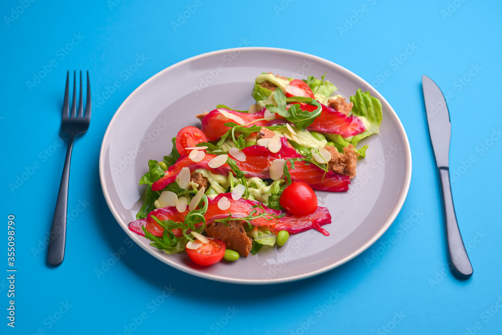 Fresh salad with smoked salted salmon, tomatoes and pumpkin seeds. Served on a gray plate over gray texture background. Fresh salad with smoked salted salmon, tomatoes and pumpkin seeds. Served on a gray plate over gray texture background.