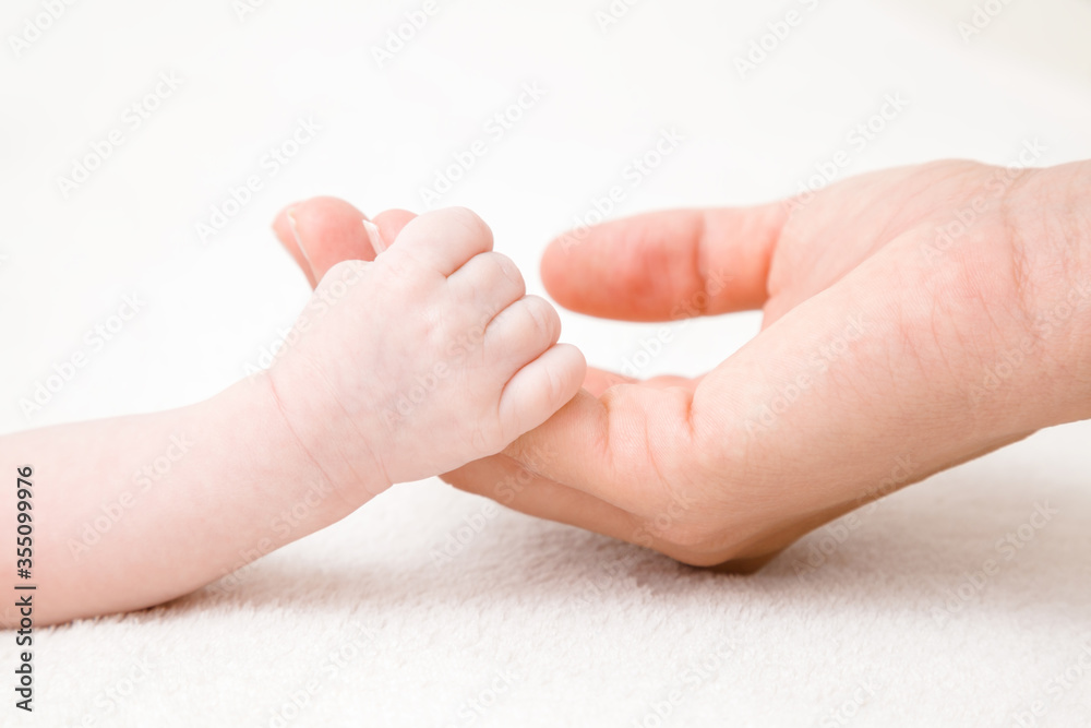Baby hand clinging young mother fingers. Closeup. Lovely, emotional, sentimental moment. Family concept. Baby hand clinging young mother fingers. Closeup. Lovely, emotional, sentimental moment. Family concept.