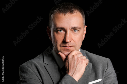 Portrait of handsome businessman on dark background