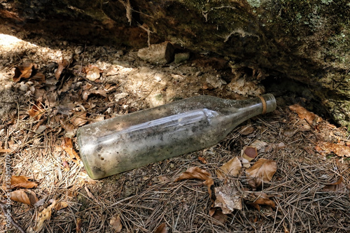 Old empty glass bottle laying in the nature