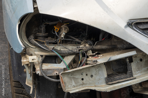 Front part of a grey passenger car damaged in an accident or traffic accident. Broken-down car, insurance payments. Disposal of damaged cars. Repair of machines.