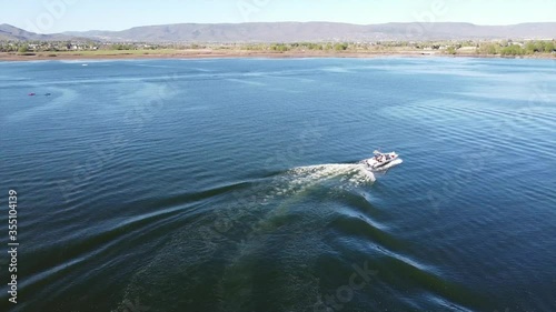 Boating and wake surfing on a smooth lake in early summer. photo