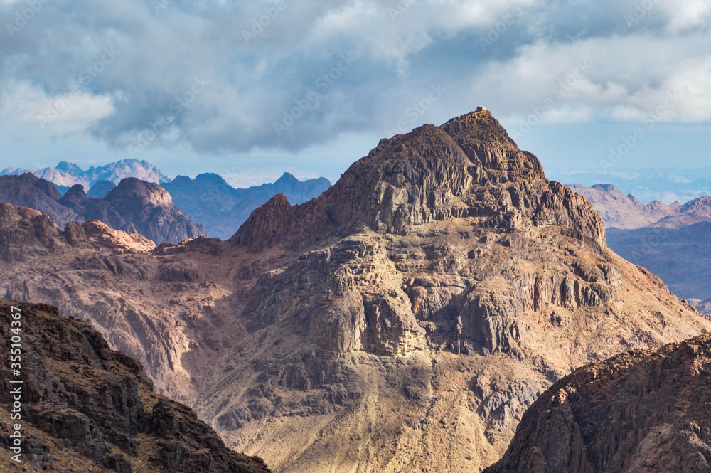 View of Moses mountain peak with a chapel on top illuminated by sunshine in the mountains of Sinai peninsula, Egypt 