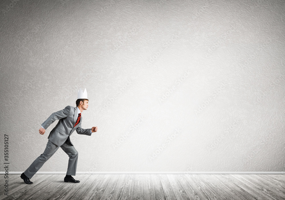 King businessman in elegant suit running in empty room King businessman in elegant suit running in empty room