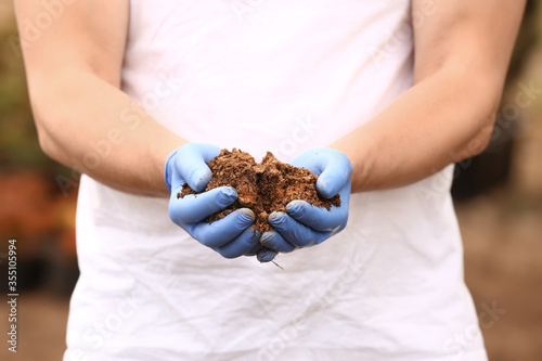 Man with heap of soil outdo...