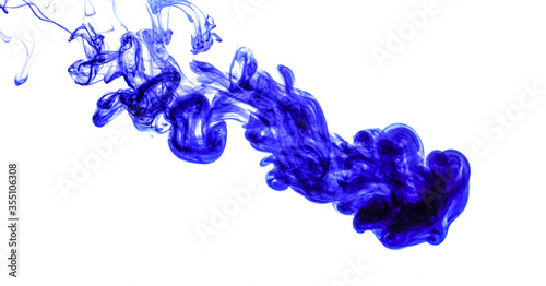 Blue ink injected into water from syringe, colour mixing with water creating abstract shapes