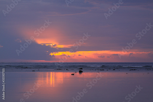 Low tide calm reef water at colorful island sunset