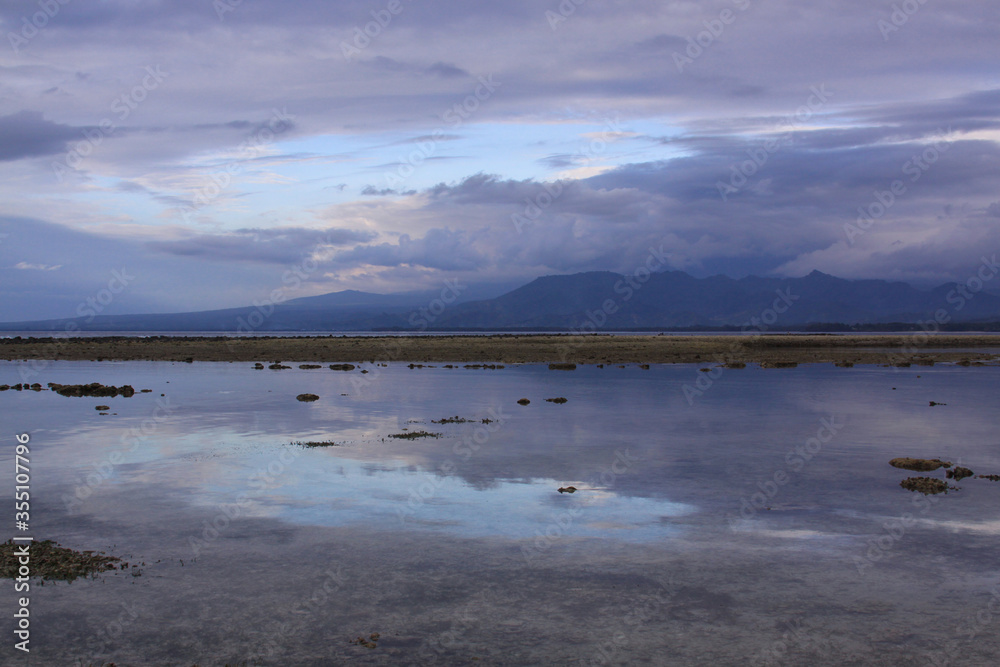 Blue clouds covering mountains and sky reflection Blue clouds covering mountains and sky reflection