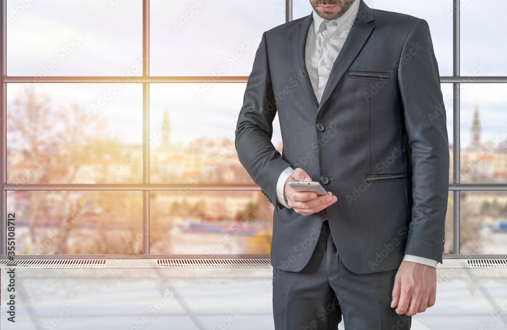 Fototapeta premium Businessman using mobile phone app texting inside office