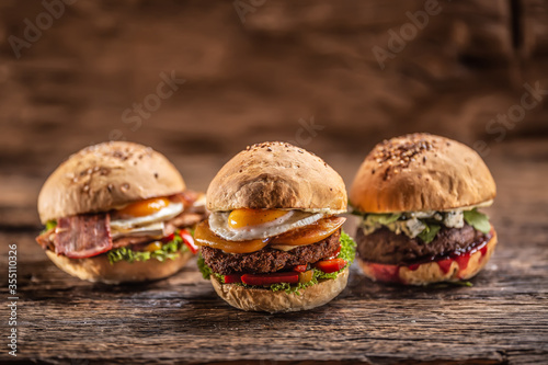 Cheeseburger, chicken burger and beef burger with blue cheese and cranberry sauce in a rustic surroundings