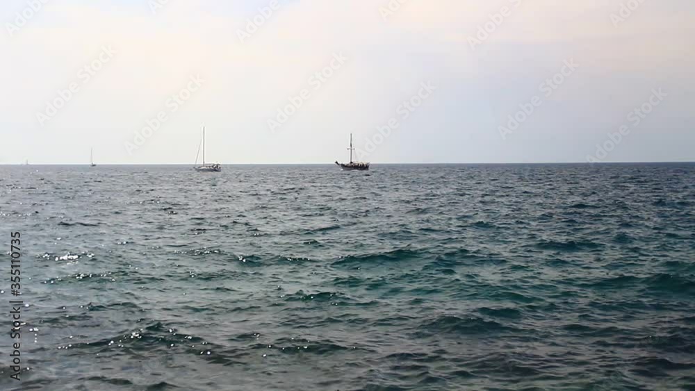 People near the sea and sailing boats. People near the sea and sailing boats.