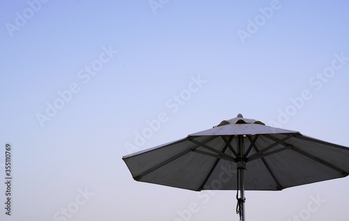 white umbrella on blue sky background © Morten H