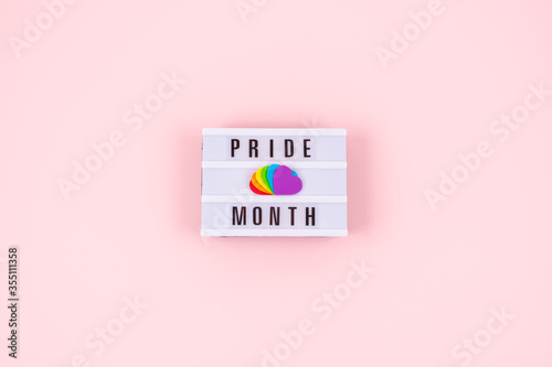 Pride month, LGBT flag symbol concept with Six rainbow color hearts on pink background with text pride month