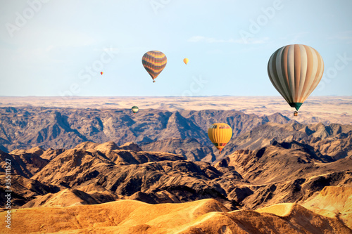Colorful balloons flying over the moon valley mountain. Africa.