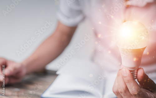 Hand man with a light bulb graphics in virtual screen, concept idea education, innovation.