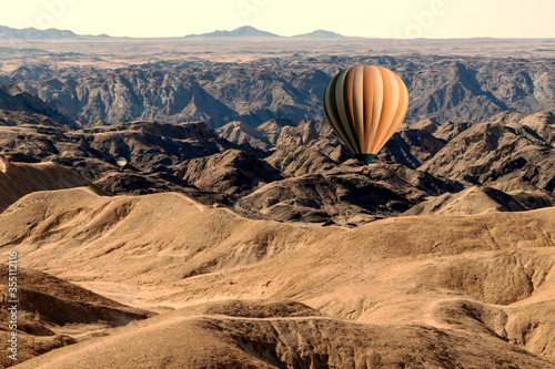 Colorful balloons flying over the moon valley mountain. Africa.