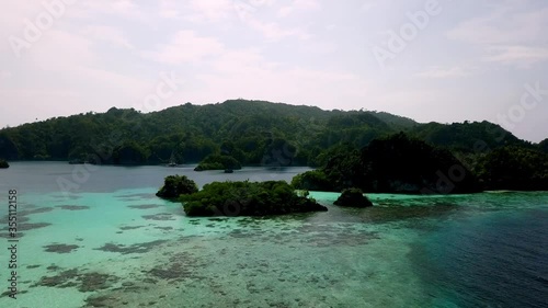 Group of Piaynemo islands with ocean lagoon in Raja Ampat area Indonesia, Aerial dolly right reveal shot photo