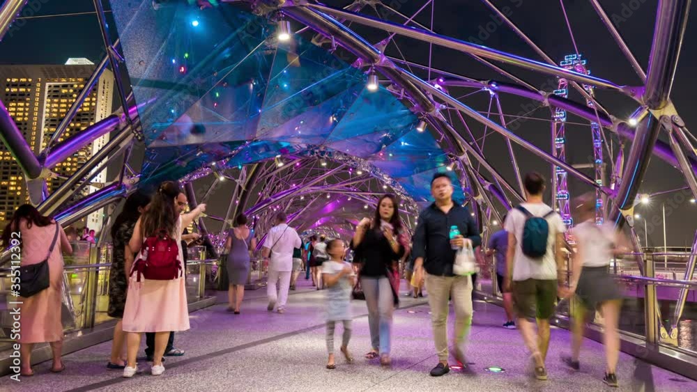 Time lapse of blurred unidentified people walking on Helix bridge in Singapore.