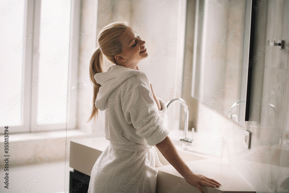Beautiful woman enjoying in hotel. Young happy woman in bathrobe use the cream for the body.
Beautiful woman enjoying in hotel. Young happy woman in bathrobe use the cream for the body.
