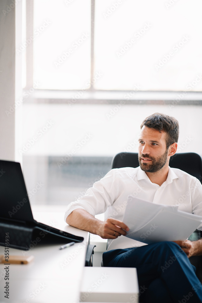 Fototapeta premium Businessman working on a project in the office. Young businessman working in office.