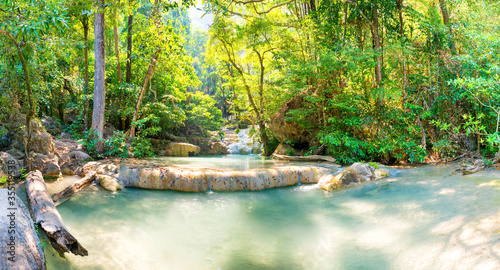 Panorama Tropical landscape with beautiful cascades of waterfall and green trees in wild jungle forest. Erawan National park, Kanchanaburi, Thailand photo