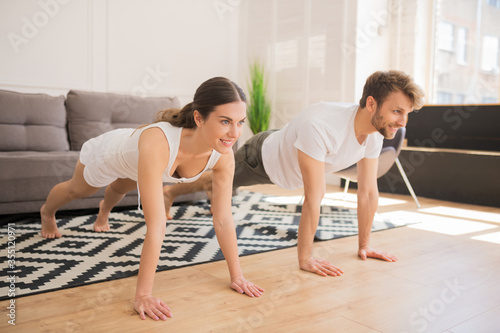 Young couple standing in plank and looking fit