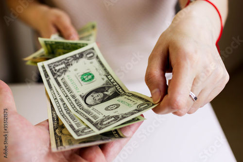 Soft focus on woman hands proposing money us dollar bills to you.