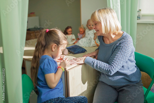 Multigenerational relations, girl and granny doing makeup together, indoor family lifestyle