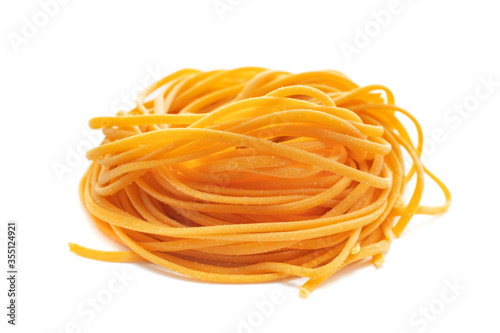 Fresh colored spaghetti pasta with carrots rolled in a nest isolated on a white background