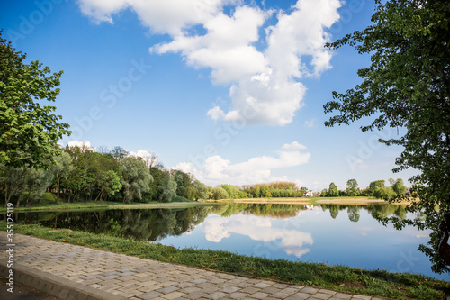 Beautiful view of the lake with a mirror reflection  in clear sunny weather. Belarus. Park Nesvizh. Historical attraction.