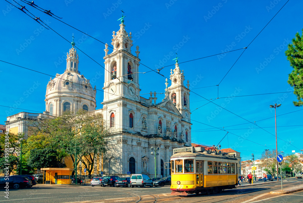 Estrela Basilica or the Royal Basilica is an ancient carmelite convent in Lisbon, Portugal. Vintage yellow tram on the old streets of Lisbon. Famous landmarks of Lisbon. - obrazy, fototapety, plakaty 