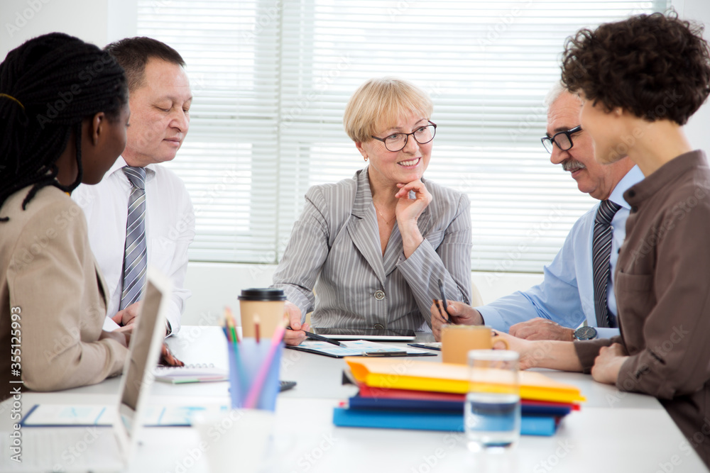 International group of business people working and communicating sitting near office desk. International group of business people working and communicating sitting near office desk.