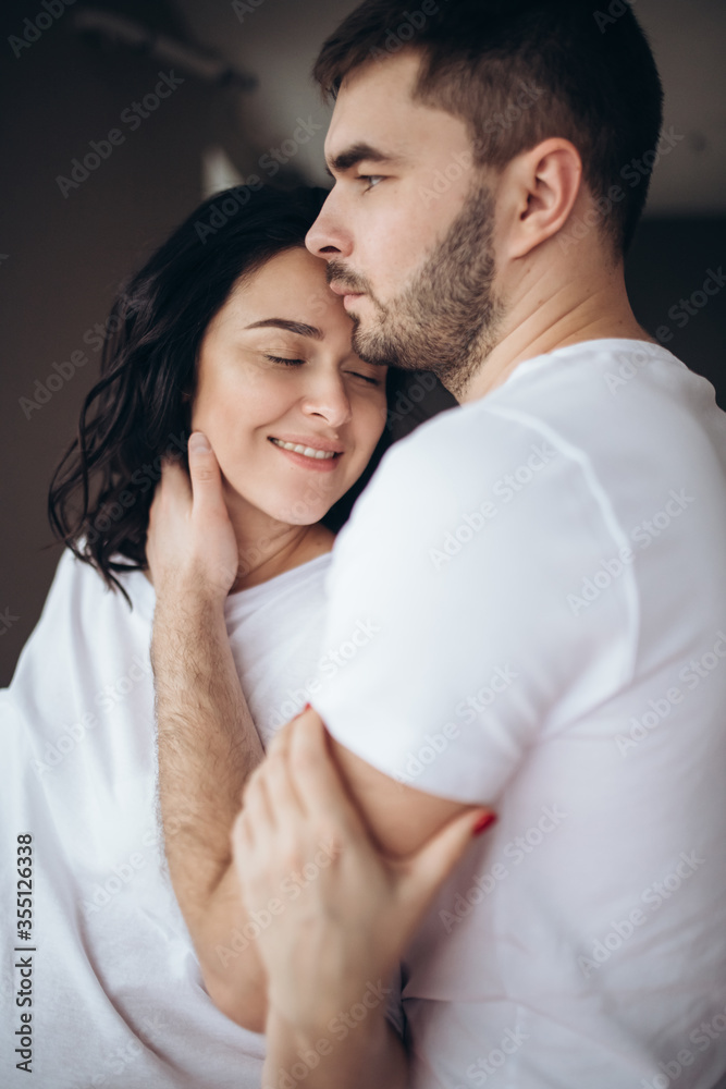 Close up portrait of a married couple in love together at home. Wife husband gently touch with foreheads closed eyes enjoy company of each other has a romantic date. First kiss concept Close up portrait of a married couple in love together at home. Wife husband gently touch with foreheads closed eyes enjoy company of each other has a romantic date. First kiss concept