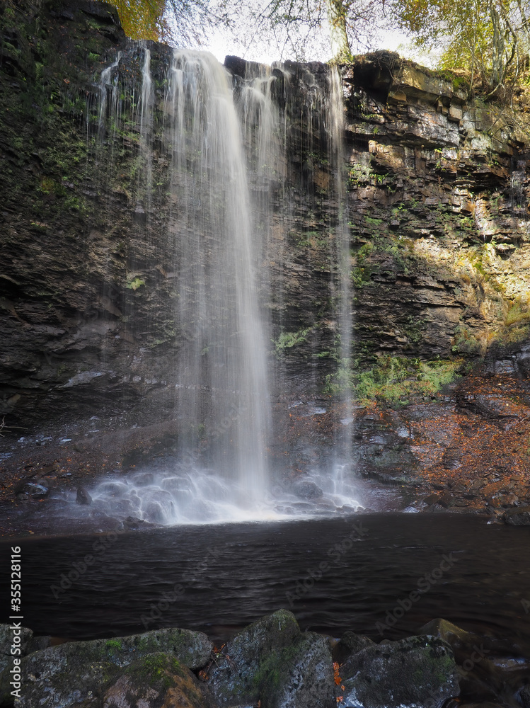 Torrent of water cascading over Whitfield Gill Force waterfall and into an idyllic pool in the woods, Askrigg, Yorkshire Dales, UK