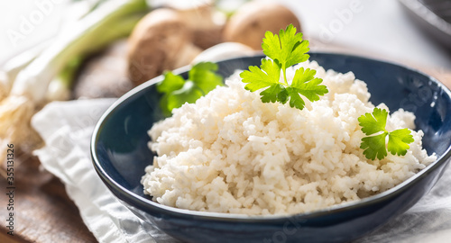 Photos Bowl of steamed rice with mushrooms and leaks in the background