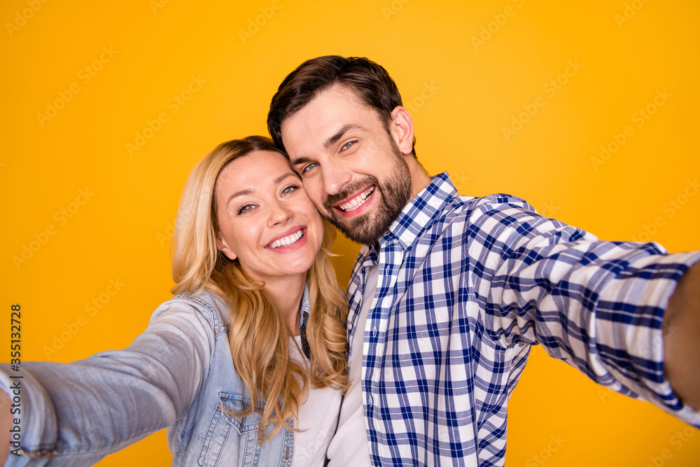 Closeup photo of pretty blond overjoyed lady handsome brunet guy couple spend quarantine together making selfies bloggers wear casual shirts isolated yellow color background Closeup photo of pretty blond overjoyed lady handsome brunet guy couple spend quarantine together making selfies bloggers wear casual shirts isolated yellow color background