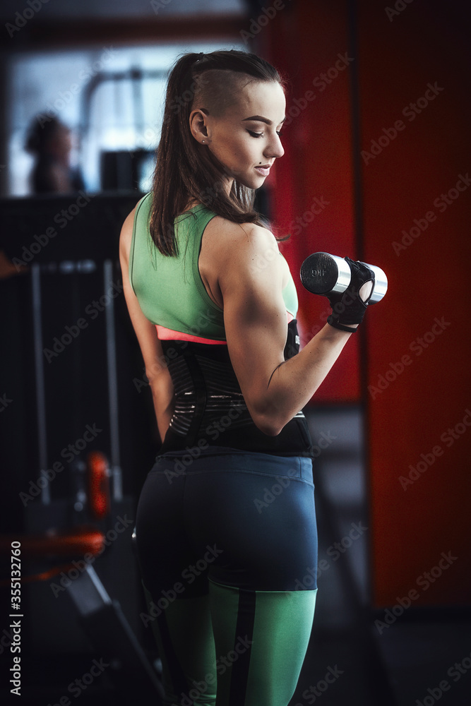 girl with dumbbells in a sports club