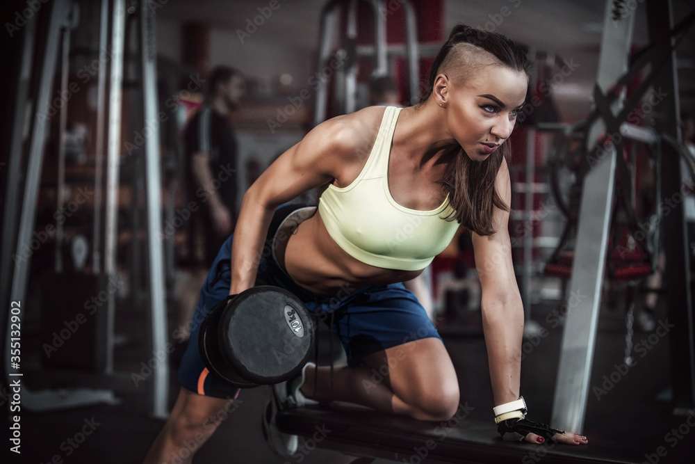 Fototapeta premium girl with dumbbells in a sports club
