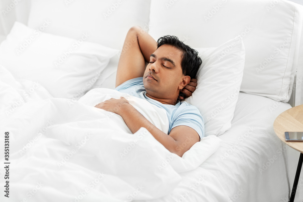 people, bedtime and rest concept - indian man sleeping in bed at home people, bedtime and rest concept - indian man sleeping in bed at home