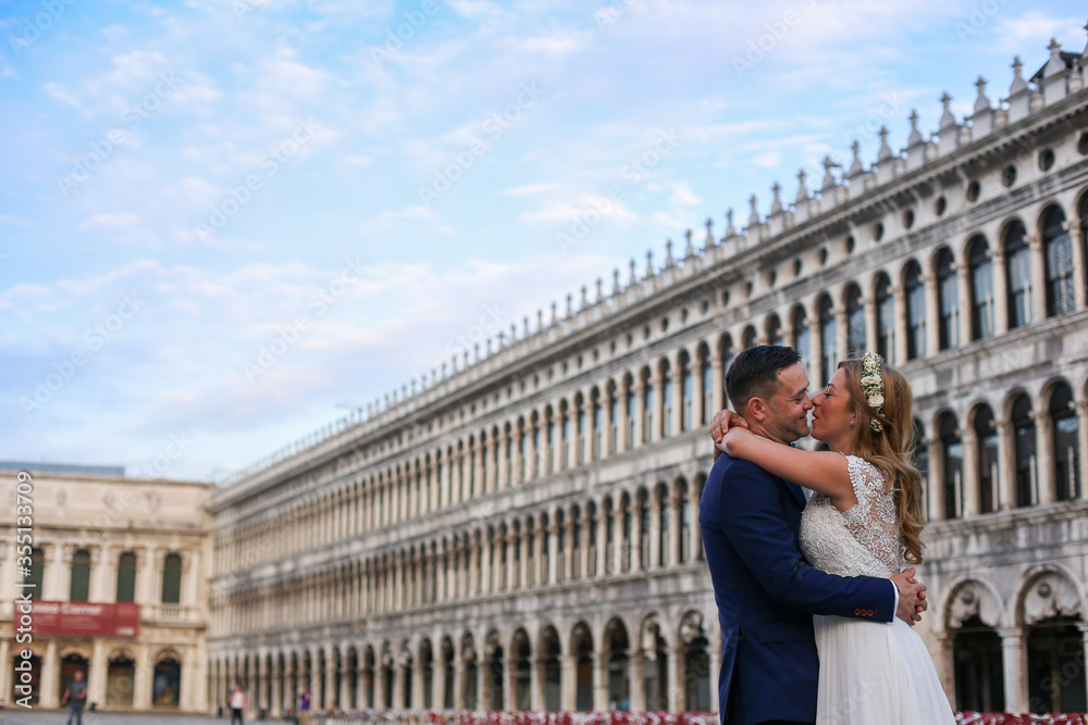 Young wedding couple posing in venice square