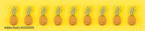 Fresh pineapples on yellow background. Top view, mockup, template, overhead. Summer concept. Creative flat lay. Horizontal long banner for web design