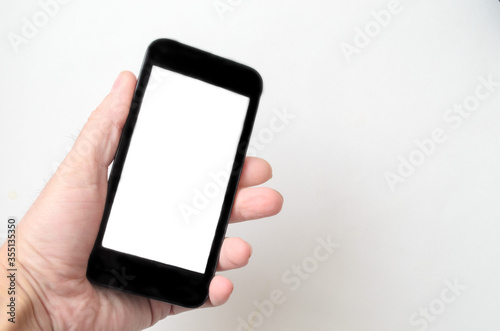 Man holds the smartphone in hand on white background, mockup.Copyspace
