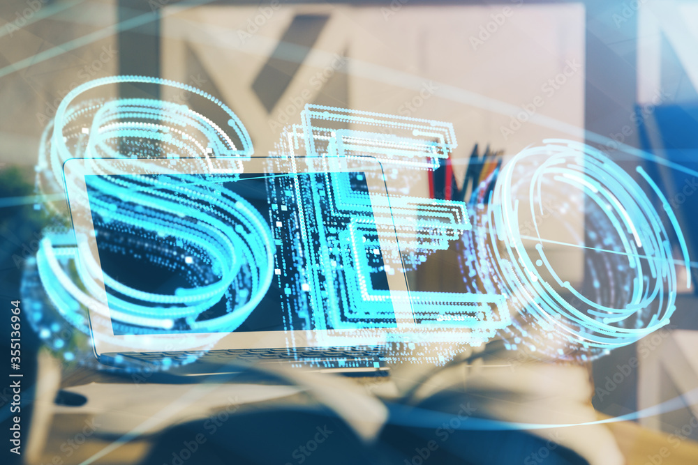 Double exposure of table with computer and seo drawing hologram. Search optimization concept.