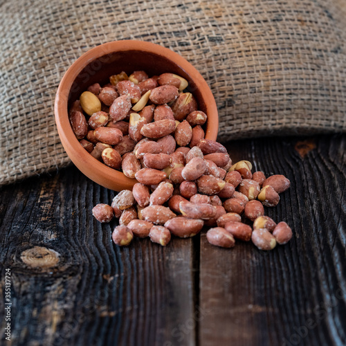 White roasted chickpeas in bowl. Turkish leblebi, famous nut, stack of yellow white roasted chickpea in burlap sack on wooden rustic background, white roasted chickpeas