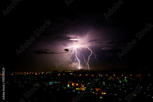 Cloudy with Bright lightning bolt strikes in the rural landscape of small city