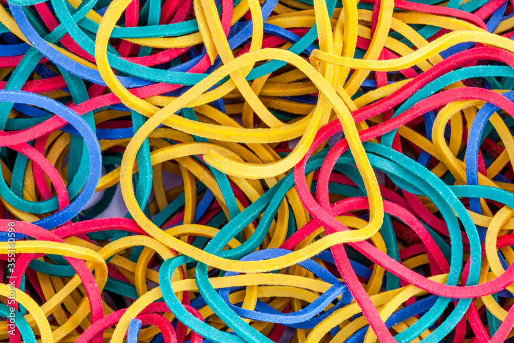 Multicolored bright elastic rubber bands colourful background in a stack heap stock photo