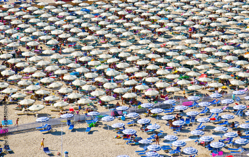 Beach umbrellas lined up on the beach of Gaeta, Italy