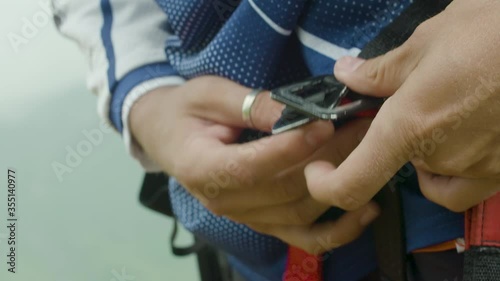 Close up of putting on the harness for paragliding in the mountains. Slow motion